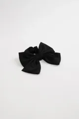 Scrunchie negro con moña grande del mismo material.