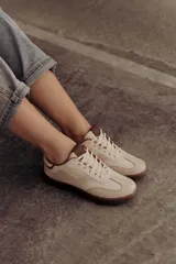 Zapatillas bajas de cuero color marrón con suela de goma color caramelo y cordones marrones.