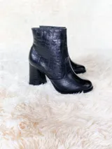 Bota corta negra con textura croco, punta redonda y taco forrado de 8.5 cm.