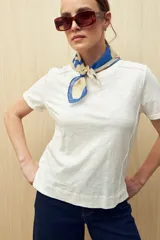 Remera blanca de algodón liviano con textura sutil, manga corta y cuello redondo.