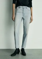 Pantalón de jean celeste, tiro alto, corte mom fit, con cinco bolsillos, cierre de cremallera y botón.