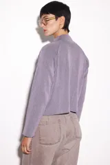 Sweater lila de punto con cuello alto y cierre de cremallera metálica.