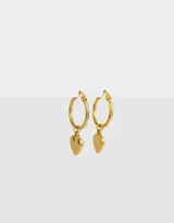 Aros dorados tipo argolla con dije de corazón colgante, hechos de acero quirúrgico.