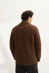 Cardigan tejido color marrón con cuello smoking, cierre con botones y bolsillos delanteros.