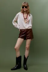 Camisa color borgoña de satén con cuello solapa, escote en pico, manga larga y cierre frontal con botones.