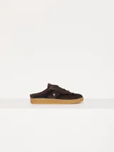 Zapatilla mule marrón de cuero vacuno descarne combinado con rafia en los laterales. Lleva cordones al tono y detalle de aplique Cherry.