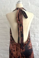 Vestido corto ajustado al cuerpo, con estampado animal print en tonos marrones y negros. Tiene escote en V pronunciado y breteles finos.
