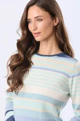 Buzo de tejido fino a rayas horizontales en tonos azul, celeste, beige y blanco, con cuello redondo y mangas largas.