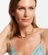 Collar corto dorado con eslabones ovalados y algunos eslabones con revestimiento brillante. Cierre con ajuste.