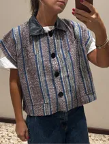 Chaleco de corte cropped con rayas en tonos marrón y azul, con cuello de cuero.