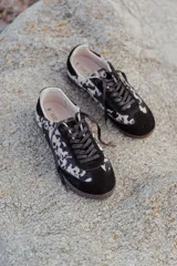 Zapatillas urbanas con capellada de cuero con estampado animal print en blanco y negro, detalles en gamuza negra, cordones negros y suela de goma.