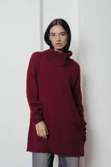 Sweater oversized color marrón con cuello alto y bolsillos frontales.