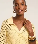 Vestido midi color amarillo pálido con efecto crochet, cuello polo, manga corta y abertura lateral. Confeccionado en algodón BCI más sostenible.