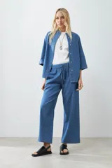 Pantalón ancho de jean color celeste con cintura elastizada y cordón ajustable.