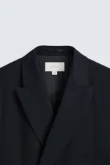 Blazer straight fit confeccionada en tejido de lana de origen italiano. Cuello con solapas de pico y manga larga acabada en puño con botones. Bolsillos de plastrón en pecho y cadera. Detalle de bolsillo interior. Bajo con aberturas en espalda. Cierre frontal de botonadura cruzada.