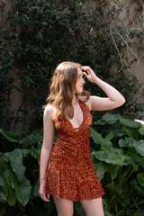 Vestido corto con lentejuelas color verde esmeralda, escote en V profundo y espalda descubierta.