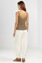 Pantalón de trabajo color crema, de corte relajado, confeccionado en lino y tencel. Con bolsillos laterales, cintura elástica, cordón ajustable y detalle regulable en el tobillo.