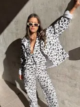 Camisa de denim con estampado de manchas de vaca, corte recto y cierre frontal con botones.