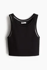 Musculosa cropped negra en punto de algodón acanalado, de corte ajustado con inserciones de encaje en escalera en escote y sisas.