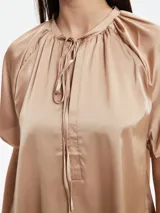 Camisa de seda color verde, con corte holgado y detalle de lazo en el escote.