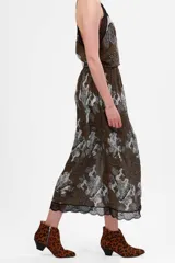 Falda midi color verde oscuro con estampado de ángeles y edificios en tonos grises, con elástico en la cintura y detalle de puntilla negra en el ruedo.