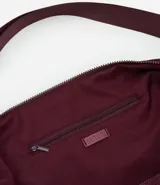 Bolso hobo mediano color gris oscuro con textura plisada y correa transversal ajustable.