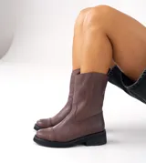 Bota de cuero vacuno color marrón, con caña media, suela de caucho y punta redonda.