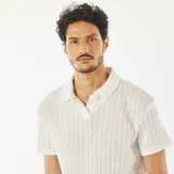 Remera blanca de punto gofrado con cuello polo y manga corta.