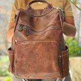 Mochila marrón de eco cuero con múltiples bolsillos con cierre y laterales.
