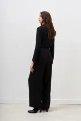 Pantalón palazzo negro con lentejuelas y mostacillas bordadas, tiro medio y cierre lateral invisible.