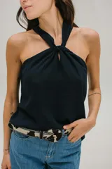 Blusa azul marino de crepe fluido con escote halter y nudo en el cuello.