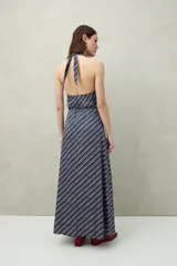 Vestido largo de algodón liviano con estampado floral en tonos azul y blanco, escote halter y lazo que se anuda al cuello.