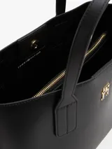 Cartera tote negra de Tommy Hilfiger, con doble asa de mano y correa de hombro textil extraíble. Presenta logo dorado de la marca en el frente y monedero extraíble con cremallera.