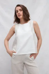 Musculosa de lino color blanco con paneles laterales en color beige, escote redondo y espalda con pliegues y cierre con botones.