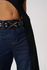 Cinturón negro de cuero con tachas plateadas y hebilla metálica en forma de X.