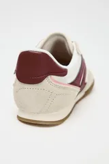 Zapatillas deportivas con combinación de colores blanco, beige y bordó. Suela en contraste color caramelo. Cierre mediante cordones.