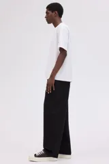 Pantalón de jean negro de corte holgado, tiro caído y piernas redondeadas extraamplias. Modelo de cinco bolsillos con cintura clásica y cierre frontal.