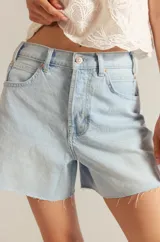 Short de jean celeste con corte holgado y ruedo desflecado.