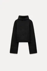 Sweater azul de tejido de punto grueso, con cuello alto y mangas largas acampanadas.