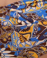 Calzón de bikini con faja cruzada y estampado abstracto en tonos marrón, azul y amarillo.