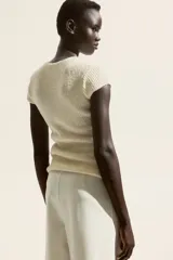 Pantalón de tiro alto color blanco, con elástico oculto en la cintura y piernas amplias con costura pespunteada doble adelante.