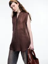 Camisa negra sin mangas con cuello mao y cierre frontal con botones.