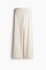 Pantalón de punto color crema, de pierna ancha y cintura alta con detalle drapeado.