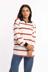 Remera de manga larga rayada en tonos blanco y rojo, con cuello polo y detalles en negro.