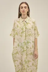 Vestido camisero largo de lino color verde claro con estampado de flores blancas, estilo oversize, con cuello camisero, mangas cortas, bolsillos laterales y botones de madera. Marca Polonio, hecho en Italia.