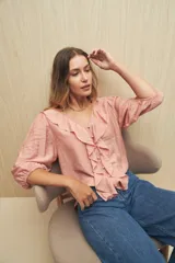 Blusa negra con mangas 3/4 y escote en V con volados.