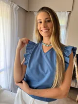 Blusa celeste con escote en V y mangas cortas con volados.