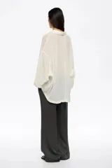 Pantalón de corte recto y tiro bajo, confeccionado en pana de algodón y viscosa color gris oscuro. Presenta bolsillos laterales de gran tamaño tipo cargo y cintura ajustable con cordón.