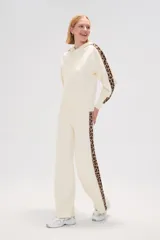 Pantalón de punto color crema, de corte ancho y tiro alto, con estampado animal print en los laterales.