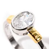 Anillo de plata 925 enchapada en rodio y oro, con zirconia oval engarzada.